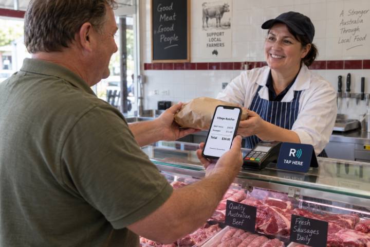 A customer views his ReceiptWave receipt while collecting a parcel at a butcher counter